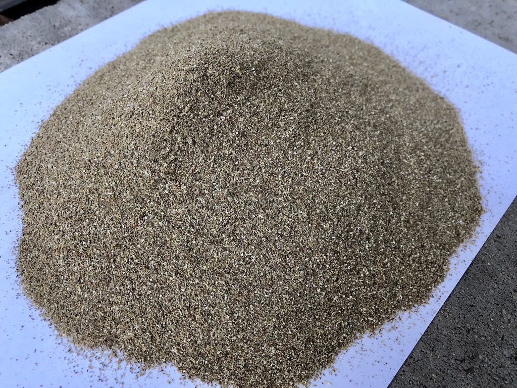 Haufen feinen, rieselfähigen Naturdüngers auf weißem Papier