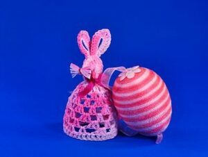 mit Garn verziertes Osterei und gehäkelter Hase