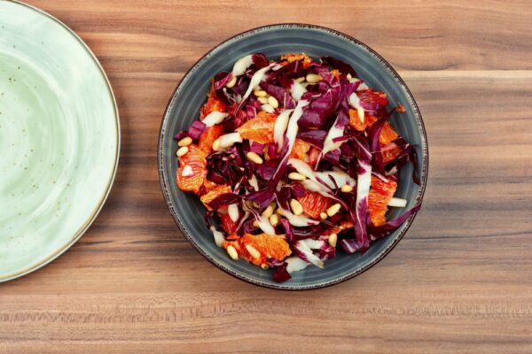 Salat aus Chicorée-Blättern mit Orangenscheiben in einer Schüssel
