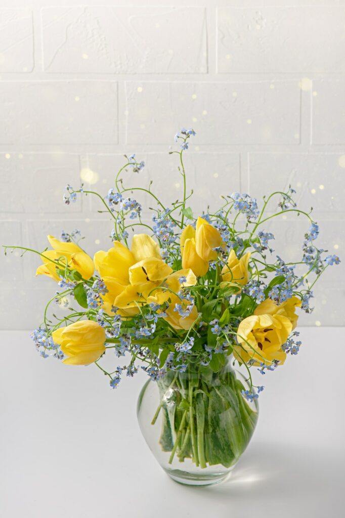 Strauß gelber Tulpen und blauer Blumen