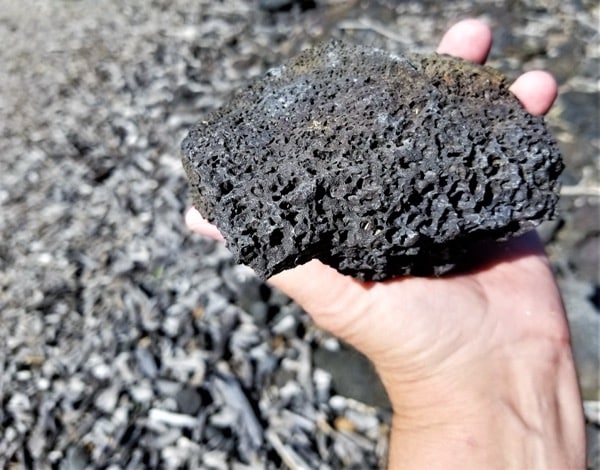 Schwarzes vulkanisches Lavagestein aus Hawaii mit grober poröser Struktur
