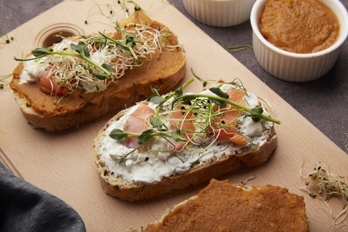 Ästhetisch zubereitete Sandwiches mit Zucchini, Frischkäse, Mungobohnen und Lachs