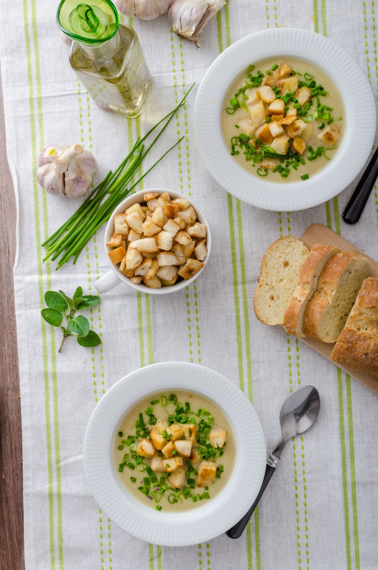 Zwei Teller Knoblauchcremesuppe mit Croutons, Schnittlauch und Baguette