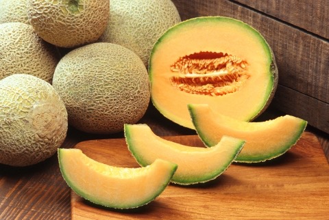 Aufgeschnittene Melone mit orangefarbenem Fruchtfleisch und genetzter Schale (Cucumis melo var. cantaloupensis)